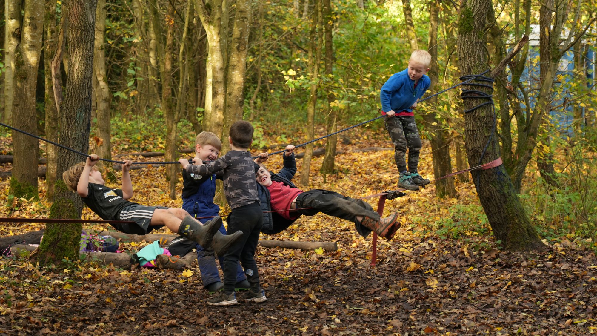 A group of boys playing on the natural woodland playground.
