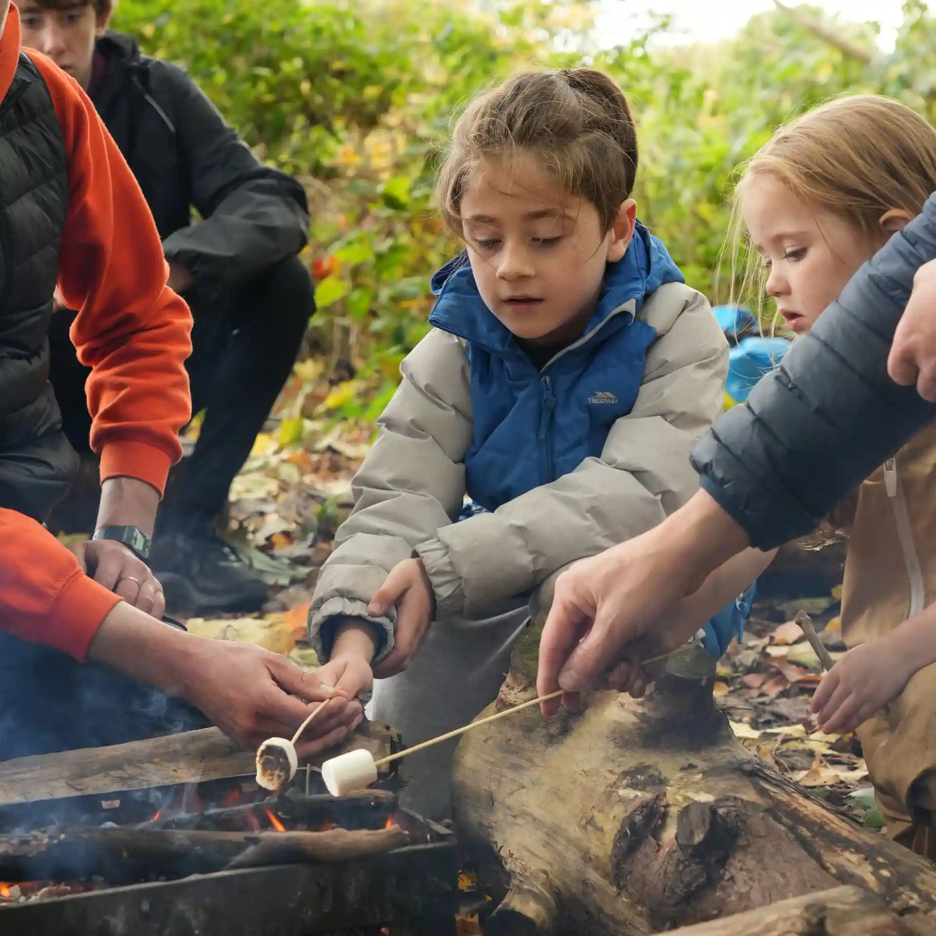 A close up of children roasting marshmallows.