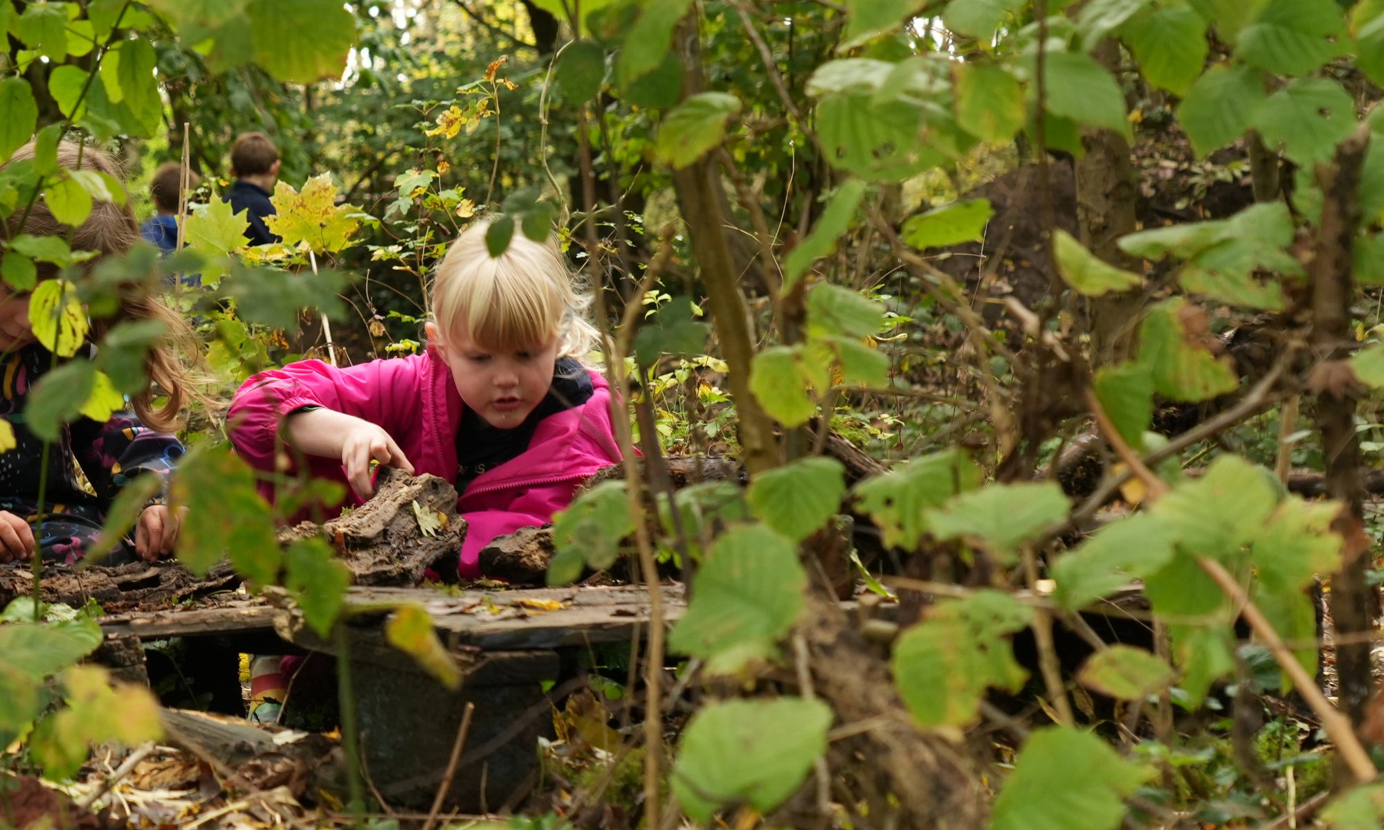 A little girl crouched down exploring nature and wildlife.