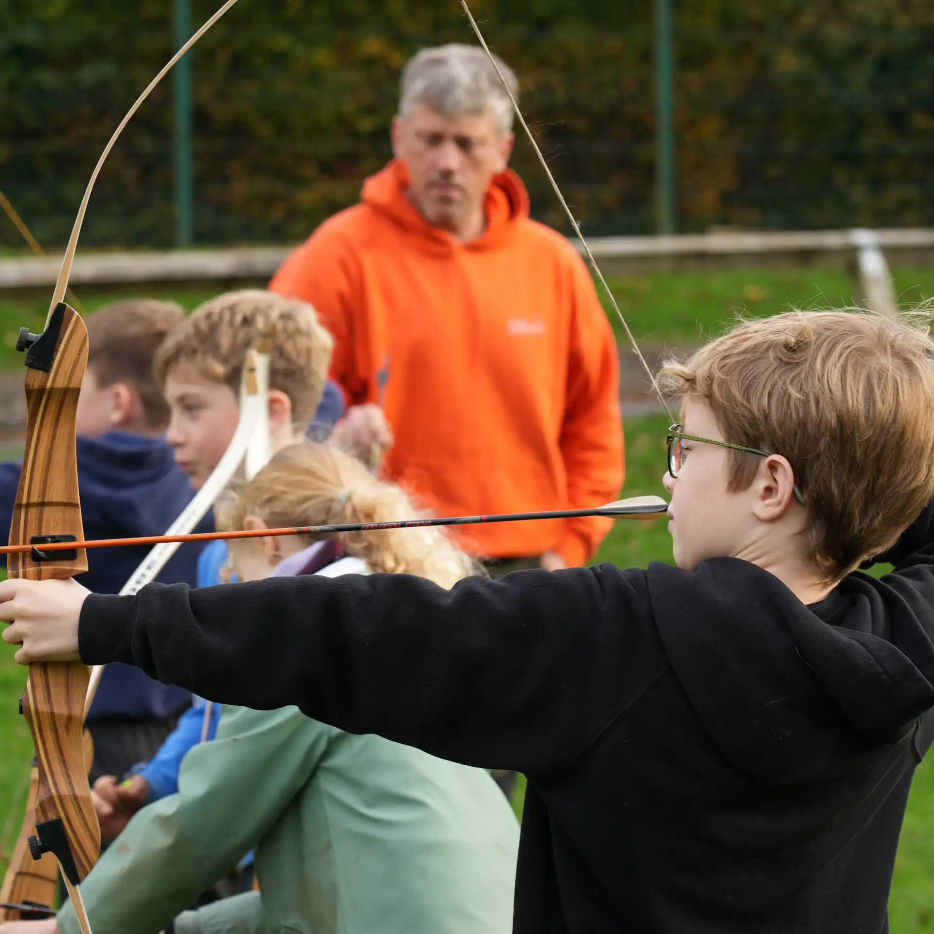 A closeup of a child taking part in an archery lesson.